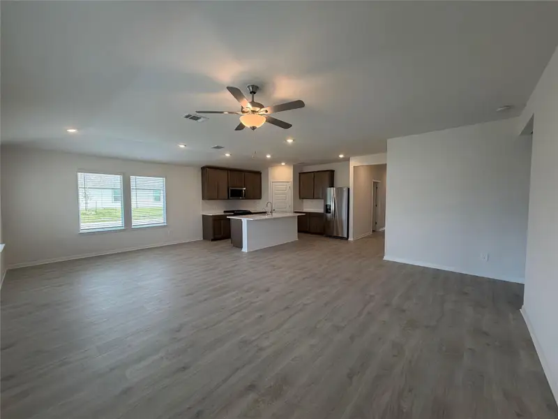 Unfurnished living room with light wood finished floors, recessed lighting, and a ceiling fan