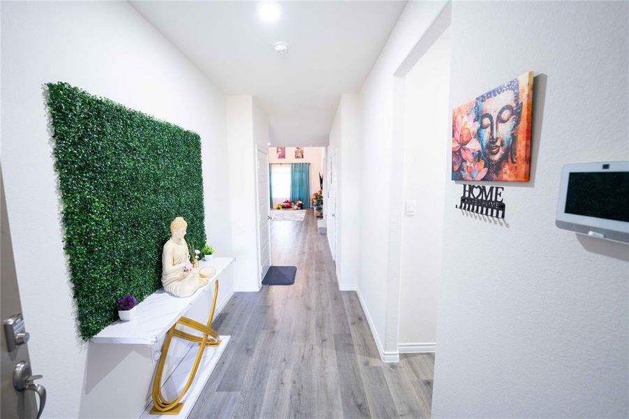 Bright hallway with wood-finish flooring, white walls, and recessed lighting Bright hallway with wood-finish flooring, white walls, and recessed lighting