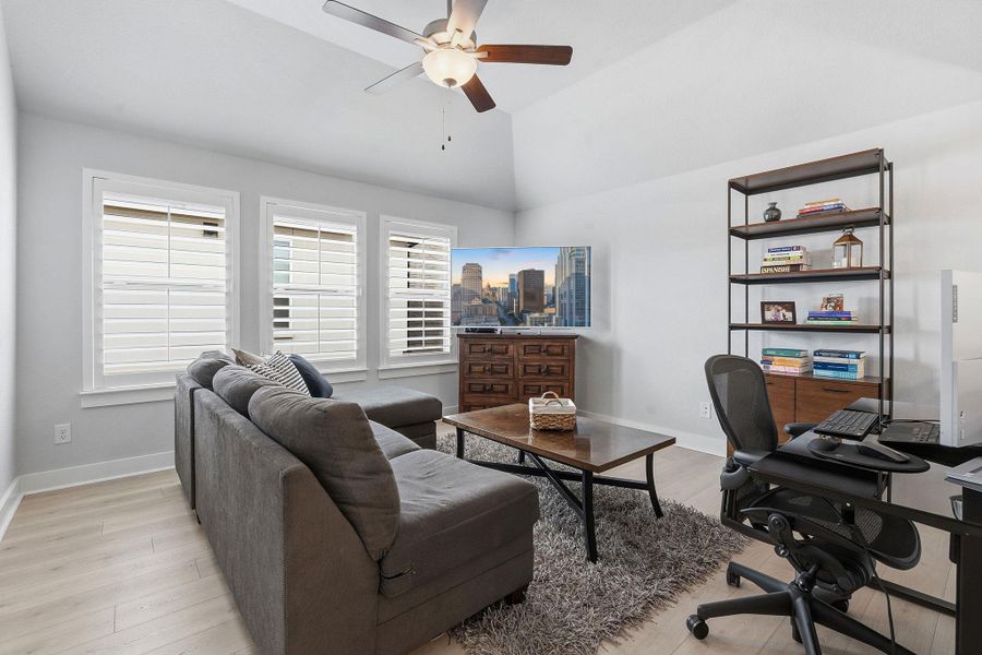 Office area with light wood-type flooring, ceiling fan, and lofted ceiling