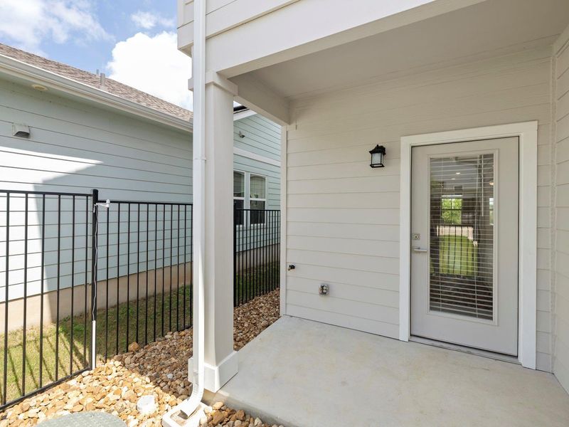A well-maintained fenced yard complements the covered patio entry of this residence.