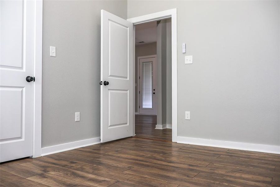 Unfurnished bedroom featuring baseboards and dark wood finished floors Unfurnished bedroom featuring baseboards and dark wood finished floors