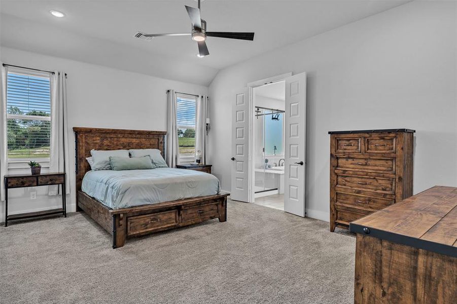 Carpeted bedroom with a vaulted ceiling, recessed lighting, and a contemporary ceiling fan