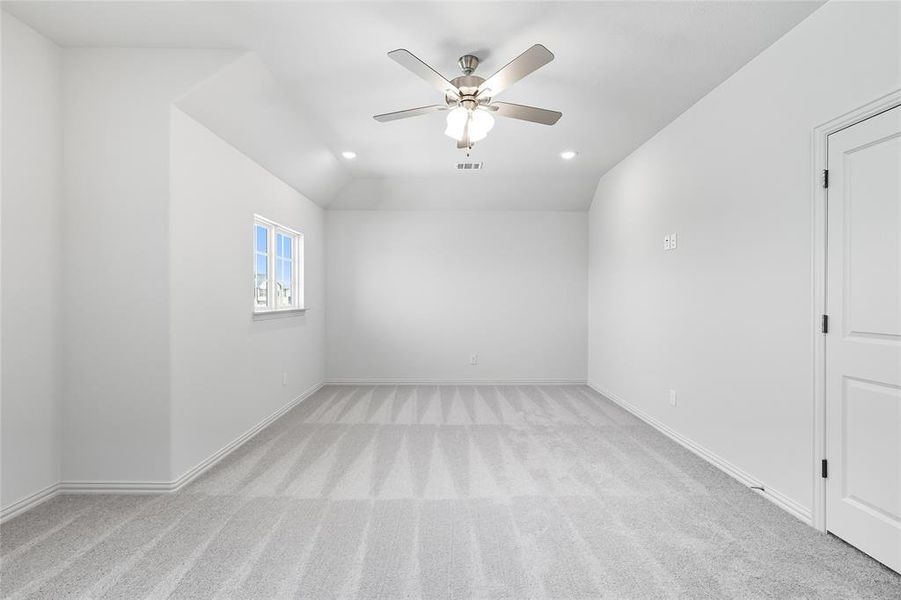 Empty room with light colored carpet, a ceiling fan, recessed lighting, and vaulted ceiling Empty room with light colored carpet, a ceiling fan, recessed lighting, and vaulted ceiling