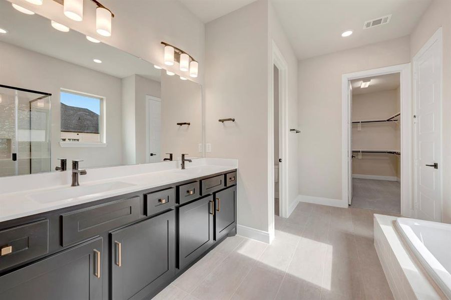 Full bath featuring double vanity, a spacious closet, a stall shower, recessed lighting, and a garden tub