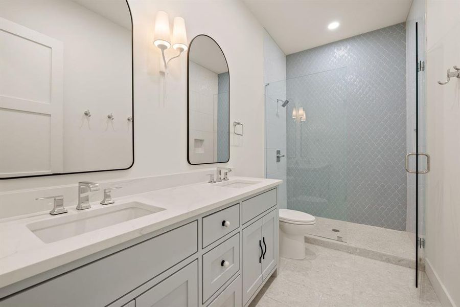 Full bathroom with a shower stall, double vanity, toilet, tile patterned flooring, and recessed lighting