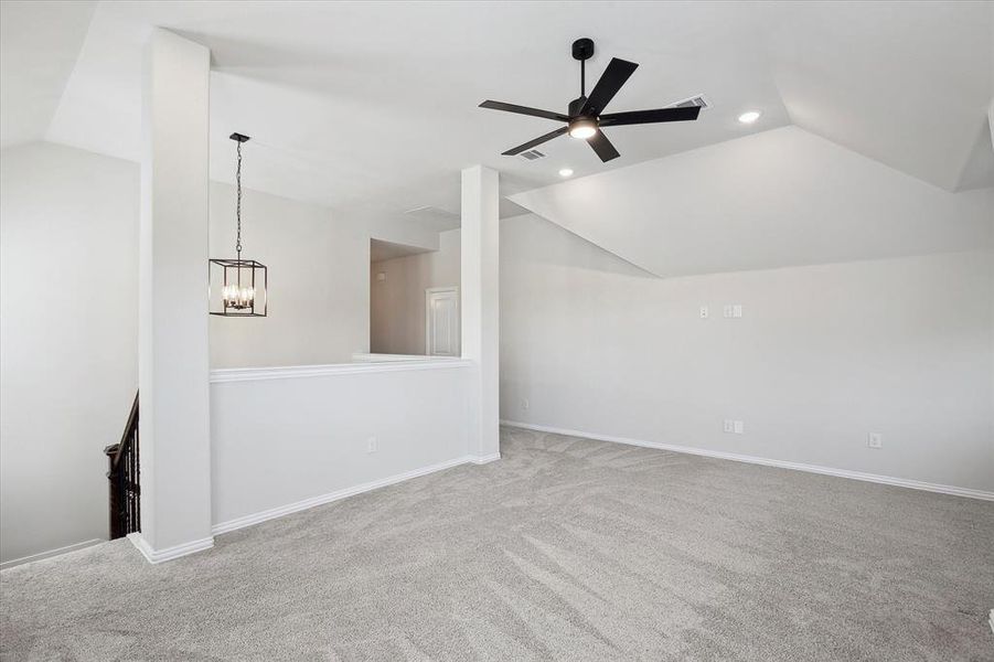 Unfurnished living room with vaulted ceiling, recessed lighting, carpet, a chandelier, and ceiling fan
