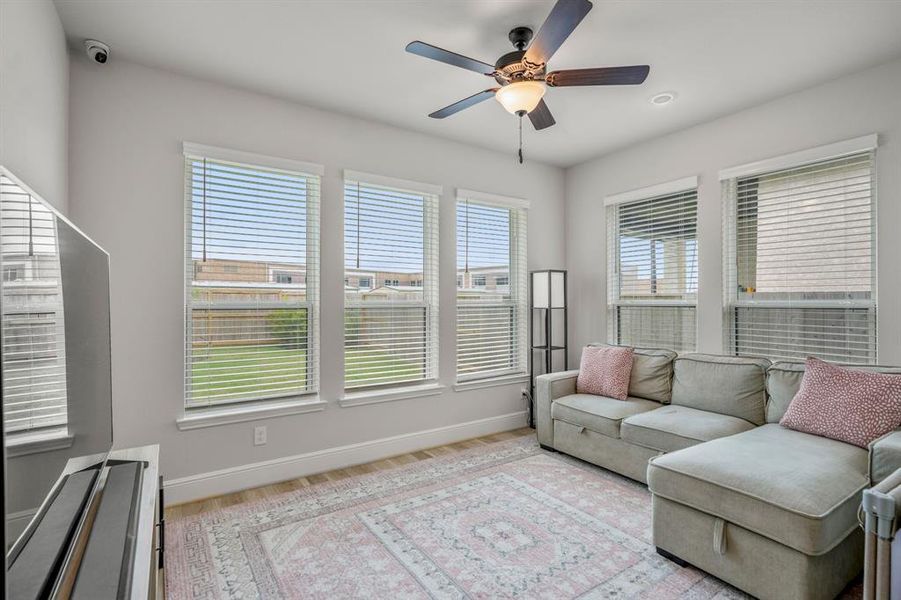 Tucked away at the back of the home off the living room is the game room or play room! It large windows letting in bright natural light, wood like flooring, and dark stained ceiling fan.