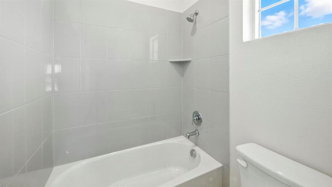 Bathroom featuring shower / bathtub combination and toilet Bathroom featuring shower / bathtub combination and toilet