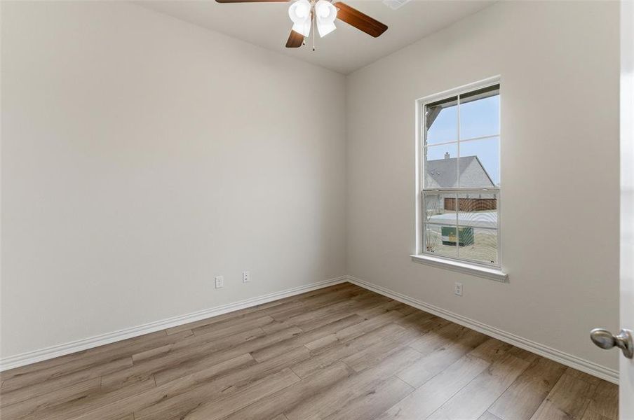Unfurnished room featuring ceiling fan and light wood-type flooring