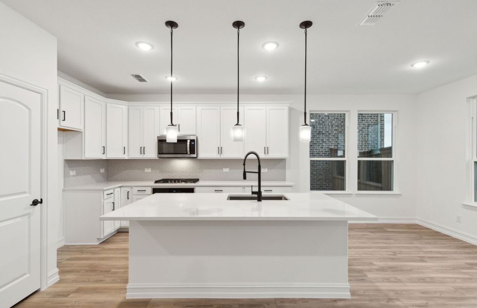 Airy kitchen with oversized island *real home pictured