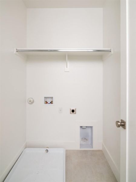 Dedicated laundry space featuring a utility sink, washer/dryer hookups, a clothing rod, and neutral flooring