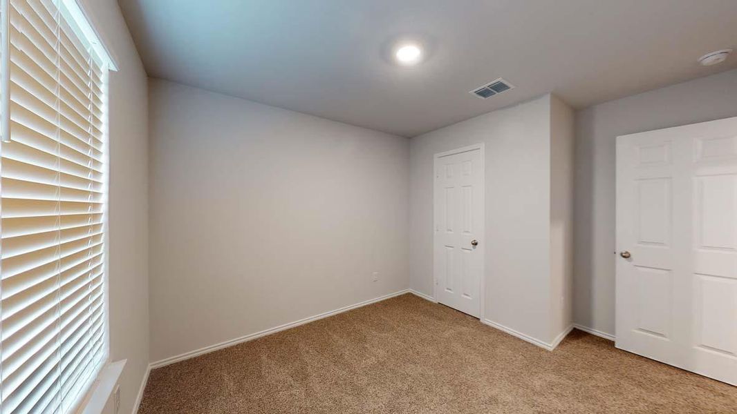 Room featuring neutral wall tones, textured carpeting, and white trim