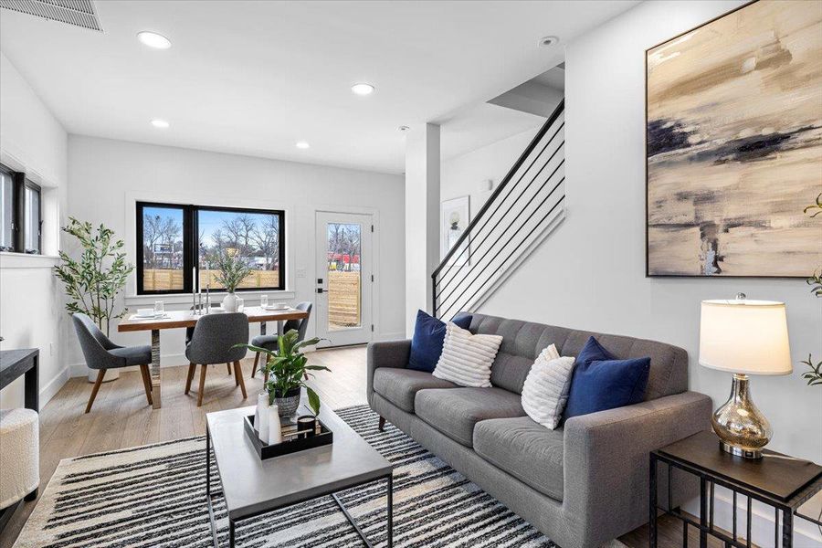 Living area featuring visible vents, recessed lighting, stairway, light wood-style floors, and baseboards