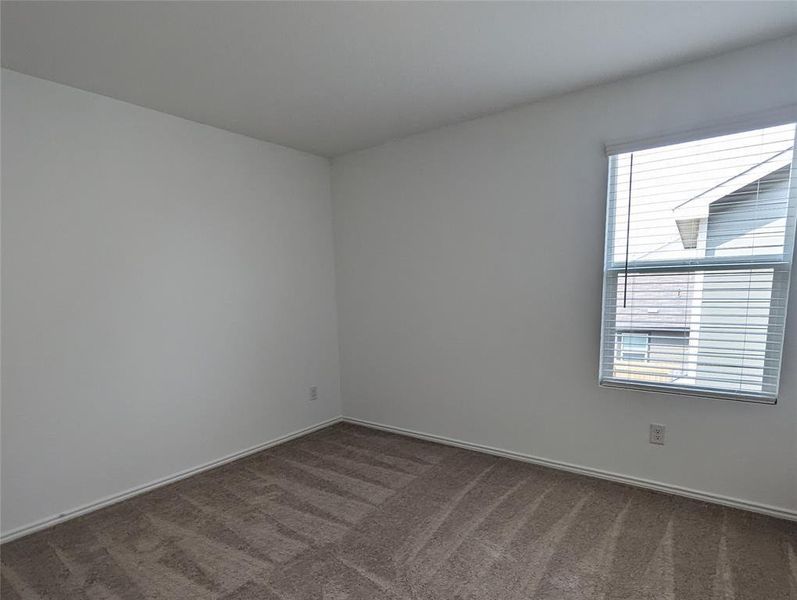 An inviting room provides a neutral canvas for personalization with durable carpet flooring.