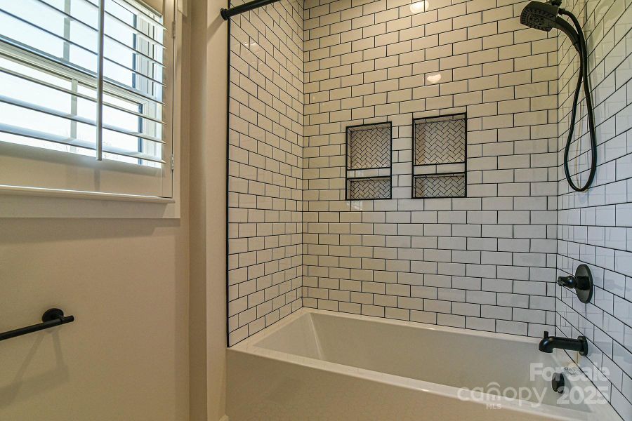 Jack and Jill bath with a large tub and tiled walls. Similar photo.