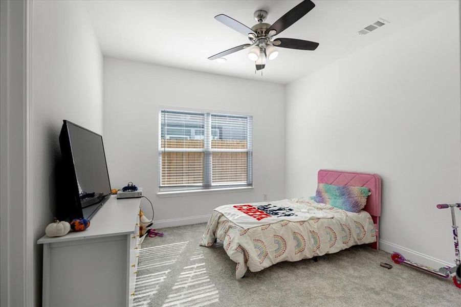 Carpeted bedroom with baseboards and a ceiling fan Carpeted bedroom with baseboards and a ceiling fan