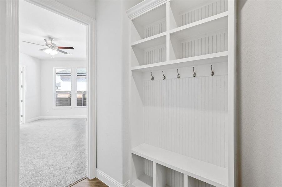 Mudroom featuring carpet floors, wood finished floors, and ceiling fan