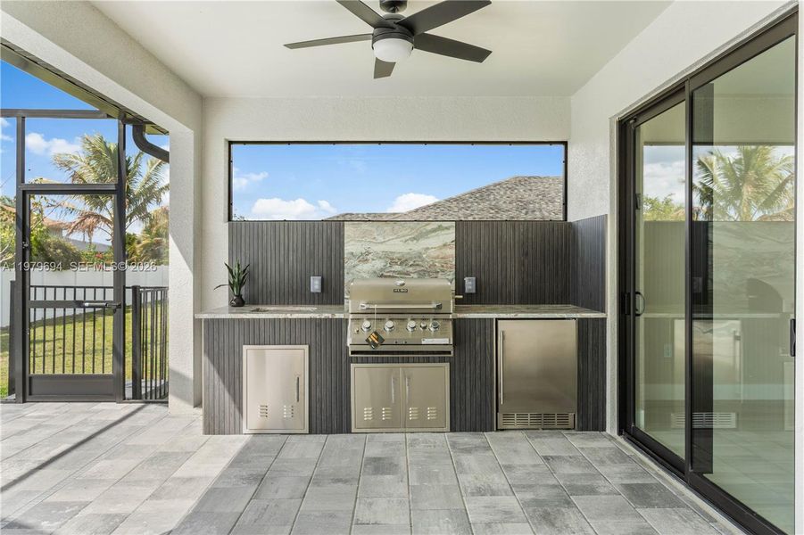 Outdoor kitchen with beverage refrigerator, 4-burner GRILL, extra storage space, and backsplash Outdoor kitchen with beverage refrigerator, 4-burner GRILL, extra storage space, and backsplash