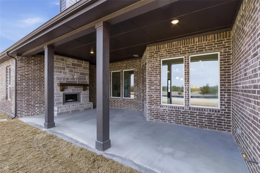 View of patio with an outdoor stone fireplace