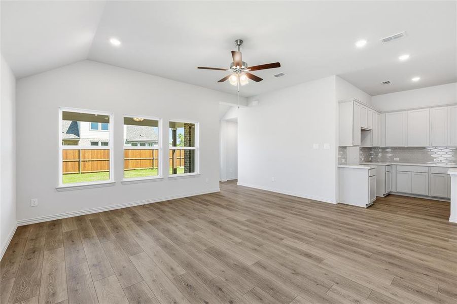 Unfurnished living room with a ceiling fan, light wood-style flooring, recessed lighting, and lofted ceiling