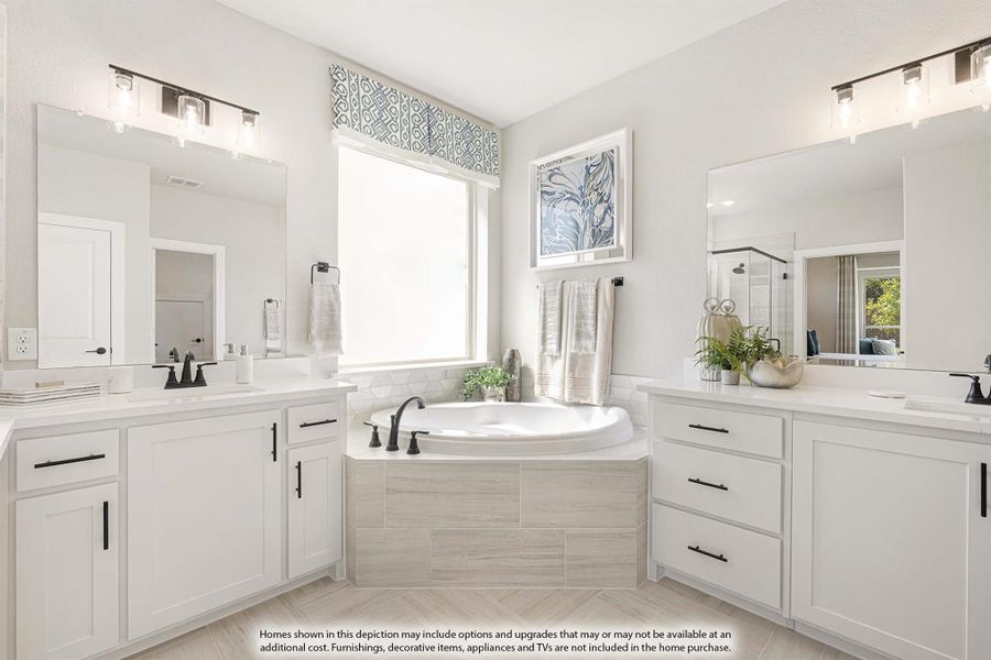 Master bathroom with dual vanities, soaking tub, white cabinets, and large mirrors on both sides