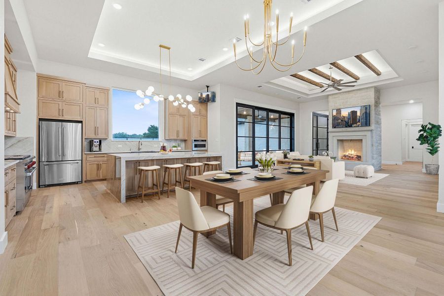 Open-concept living space featuring wide-plank wood-finish flooring, a contemporary kitchen with light wood cabinetry and stainless steel appliances, and a central island with waterfall countertops