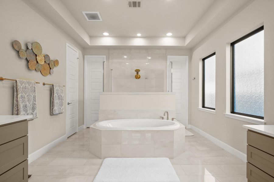 Full bath featuring vanity, recessed lighting, a garden tub, walk in shower, and a raised ceiling Full bath featuring vanity, recessed lighting, a garden tub, walk in shower, and a raised ceiling