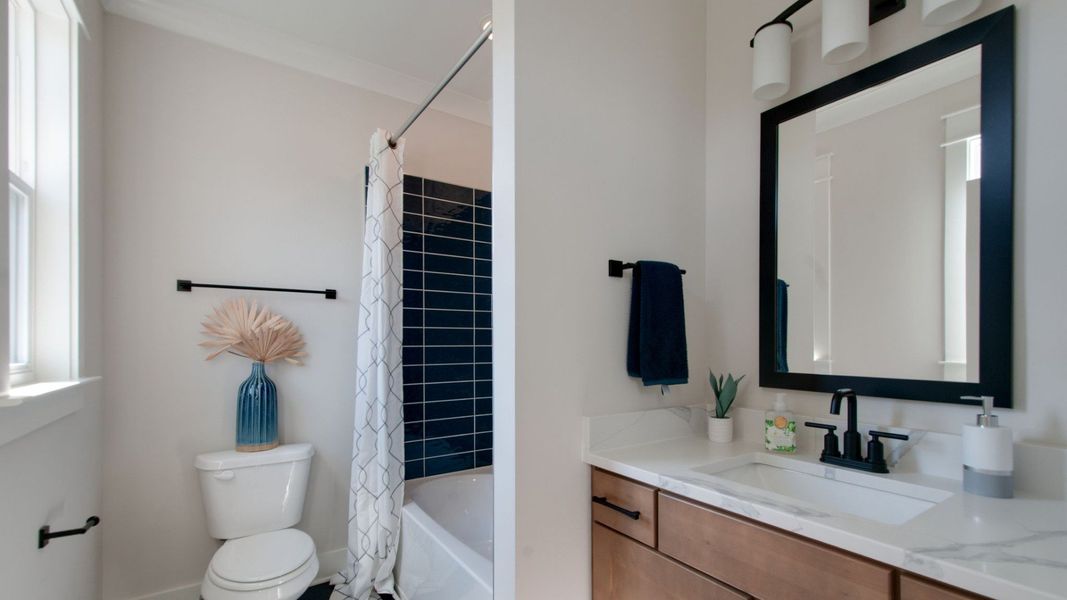 Secondary Bathroom with shower, toilet, and vanity with natural light Secondary Bathroom with shower, toilet, and vanity with natural light