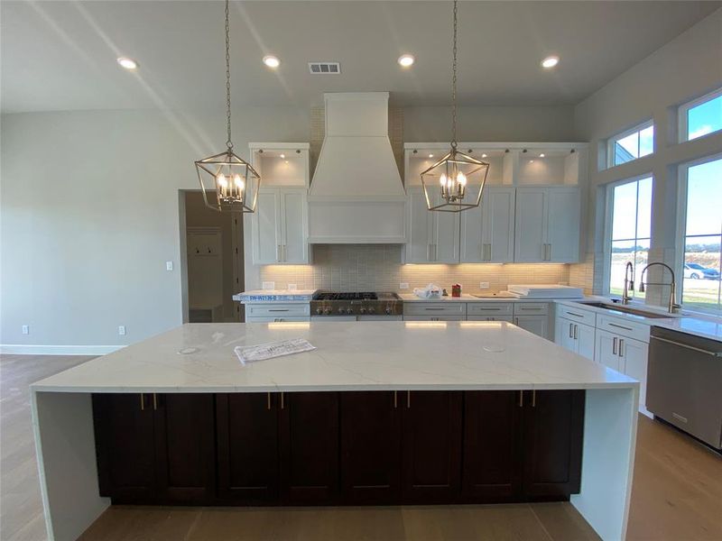 Kitchen featuring light stone countertops, white cabinetry, decorative backsplash, stainless steel appliances, and recessed lighting