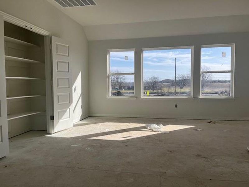 Empty room with visible vents and vaulted ceiling