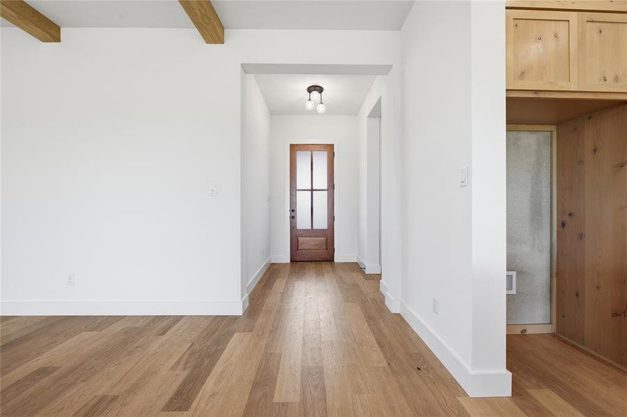 Entrance foyer with light wood finished floors and beamed ceiling Entrance foyer with light wood finished floors and beamed ceiling