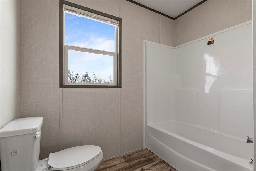 Full bath featuring wood finished floors, tub / shower combination, and crown molding