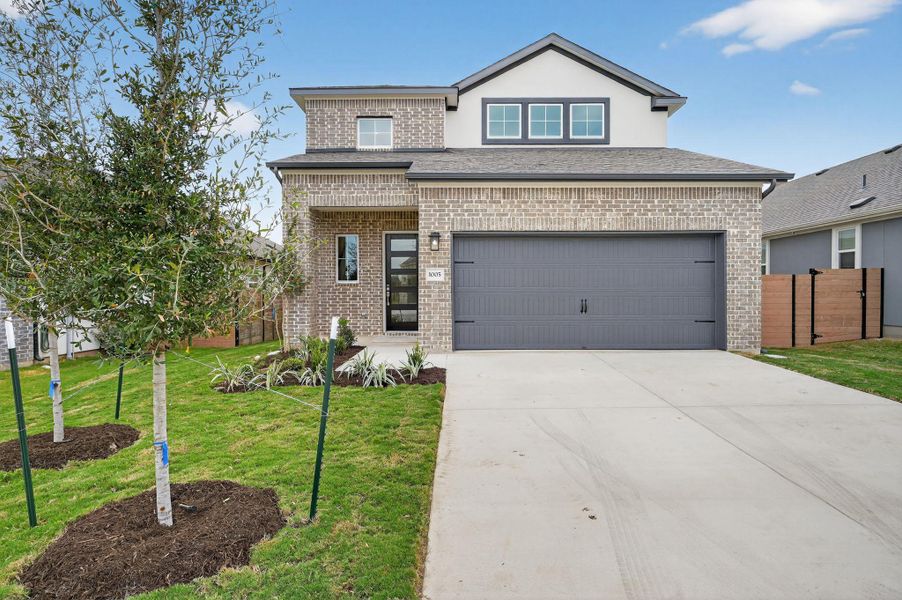View of front of house with brick siding, concrete driveway, a porch, and stucco siding