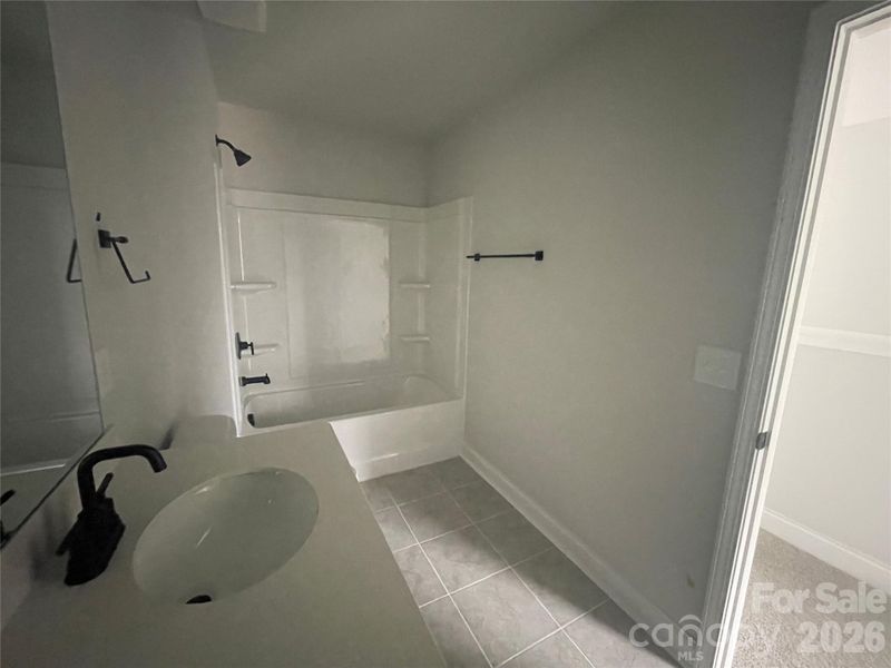 The secondary upstairs hall bathroom also has dual sinks and linen closet