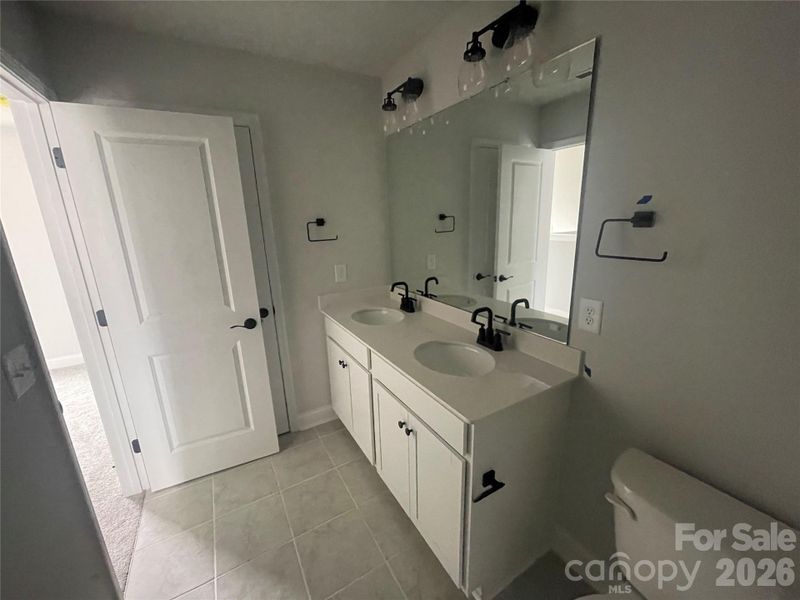 The secondary upstairs hall bathroom also has dual sinks and linen closet