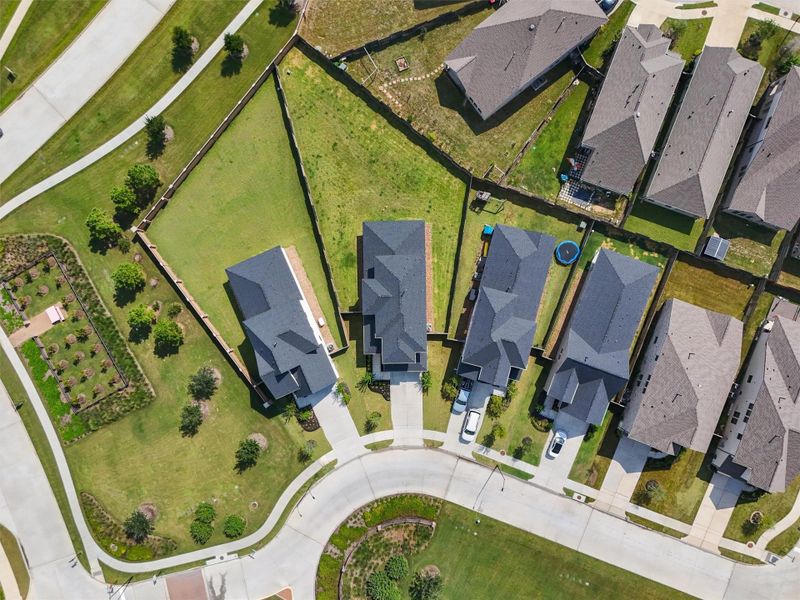 From this top-down view, you can truly appreciate the generous lot size and the extensive side yard space on both sides of the home. The yard is fully fenced, providing privacy and a secure area for outdoor activities.