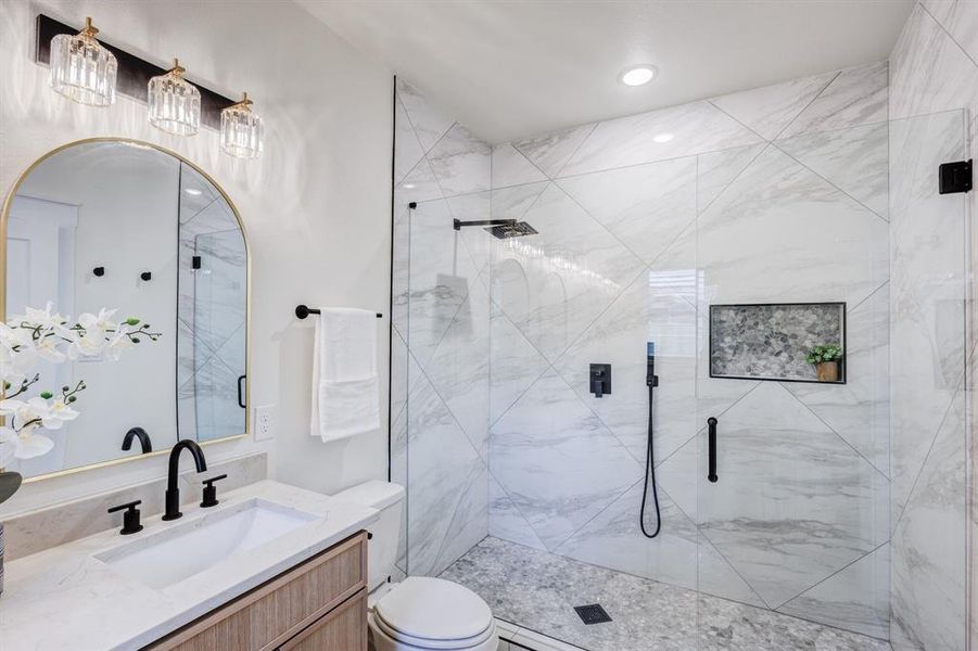 Bathroom featuring vanity, toilet, and an enclosed shower