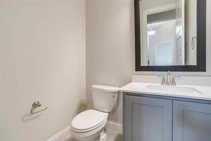 Bathroom featuring vanity, tile patterned flooring, and toilet