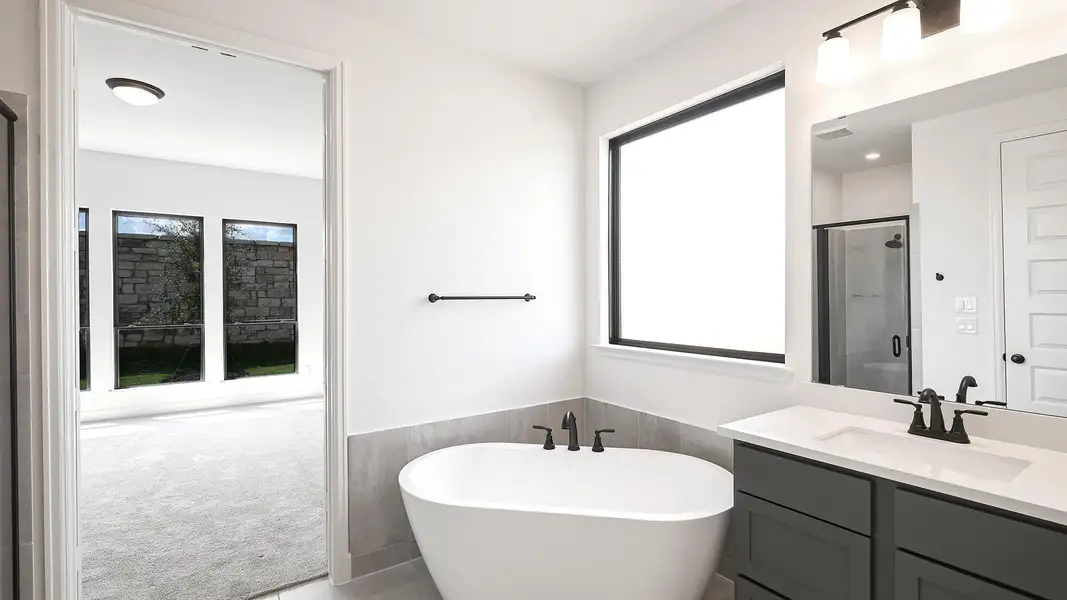 Full bathroom with vanity, a stall shower, a freestanding bath, and a wainscoted wall Full bathroom with vanity, a stall shower, a freestanding bath, and a wainscoted wall