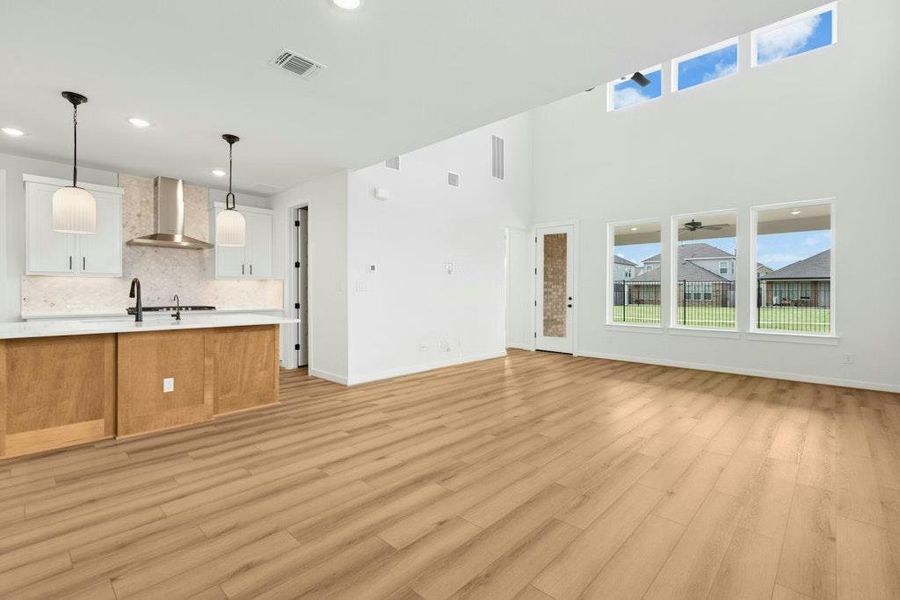 Unfurnished living room featuring plenty of natural light, light wood-style flooring, and recessed lighting