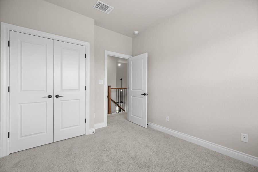 Unfurnished bedroom with light colored carpet and a closet