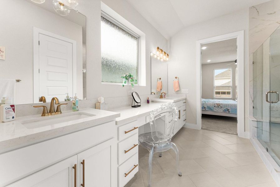 The master bathroom has herringbone tile flooring, multi-height vanity with two sinks, a frameless shower with bench, water closet, and rainfall window.