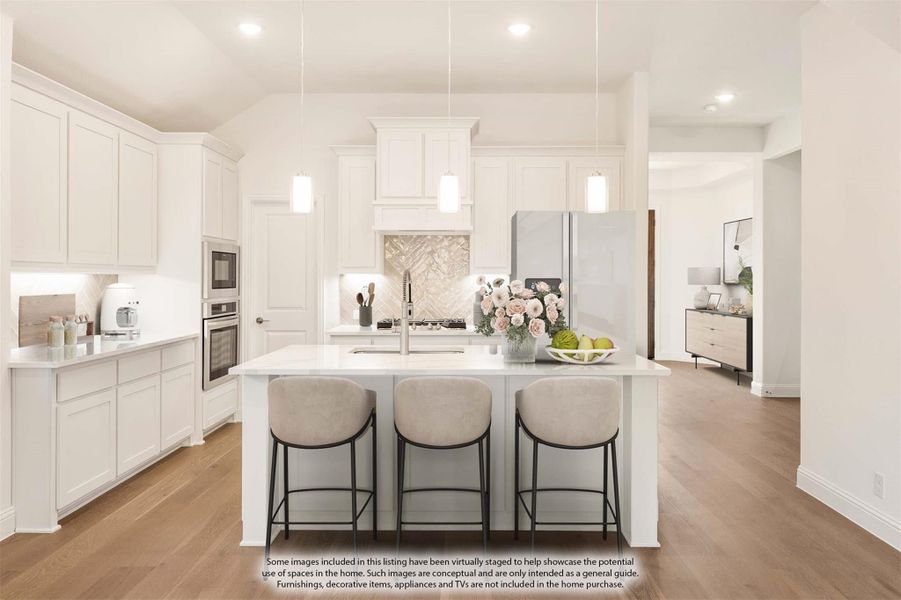White kitchen with center island, three bar stools, pendant lights, and stainless steel appliances on hardwood floors White kitchen with center island, three bar stools, pendant lights, and stainless steel appliances on hardwood floors