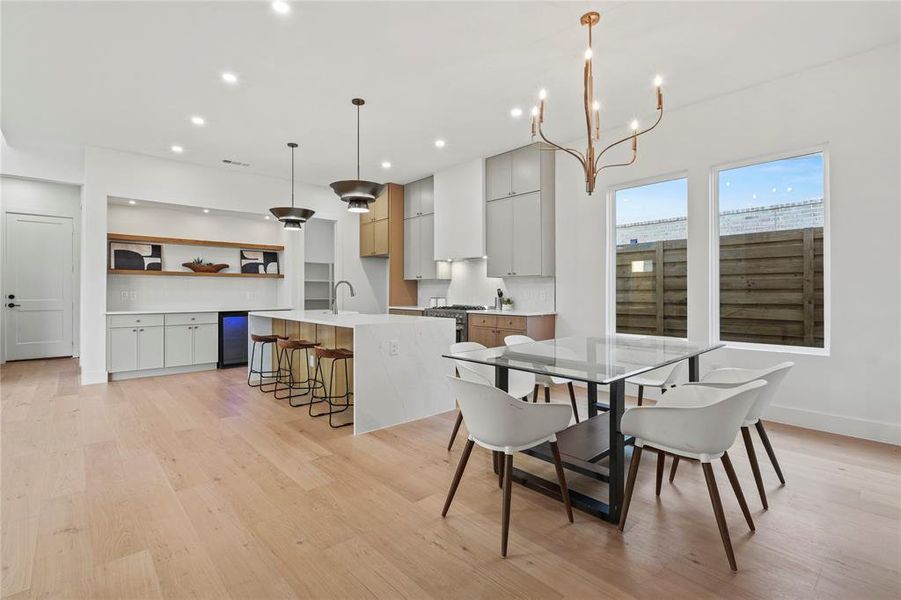 Dining space featuring light wood-type flooring, a chandelier, and recessed lighting