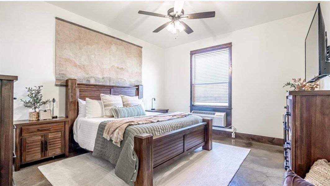 Bedroom with baseboards, concrete floors, and ceiling fan Bedroom with baseboards, concrete floors, and ceiling fan