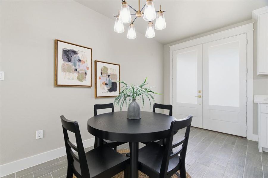 Dining space featuring a chandelier, wood finish floors, and french doors