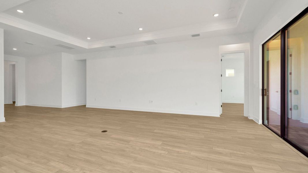 The Living Room of a DRB Homes Grand Hawk which is offered as a home plan at Serengeti in Spring Hill, FL.