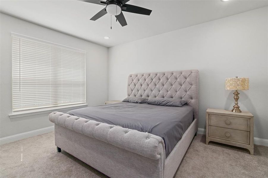 Bedroom featuring ceiling fan and light colored carpet