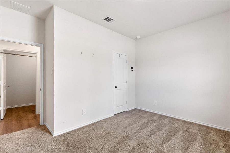 Carpeted room featuring light-colored walls and white trim