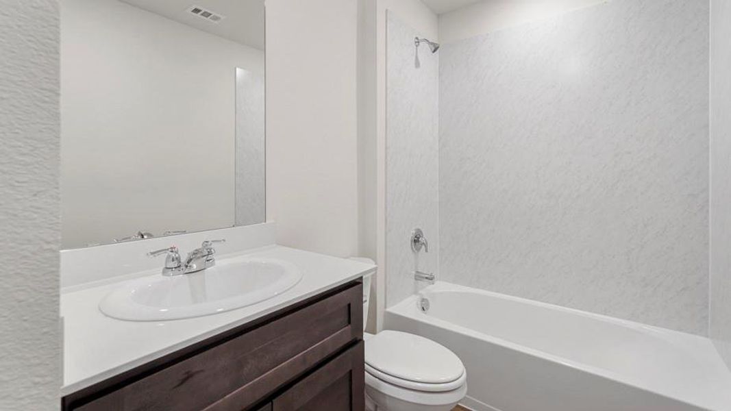 Bathroom vanity with integrated sink, chrome faucet, and expansive mirror